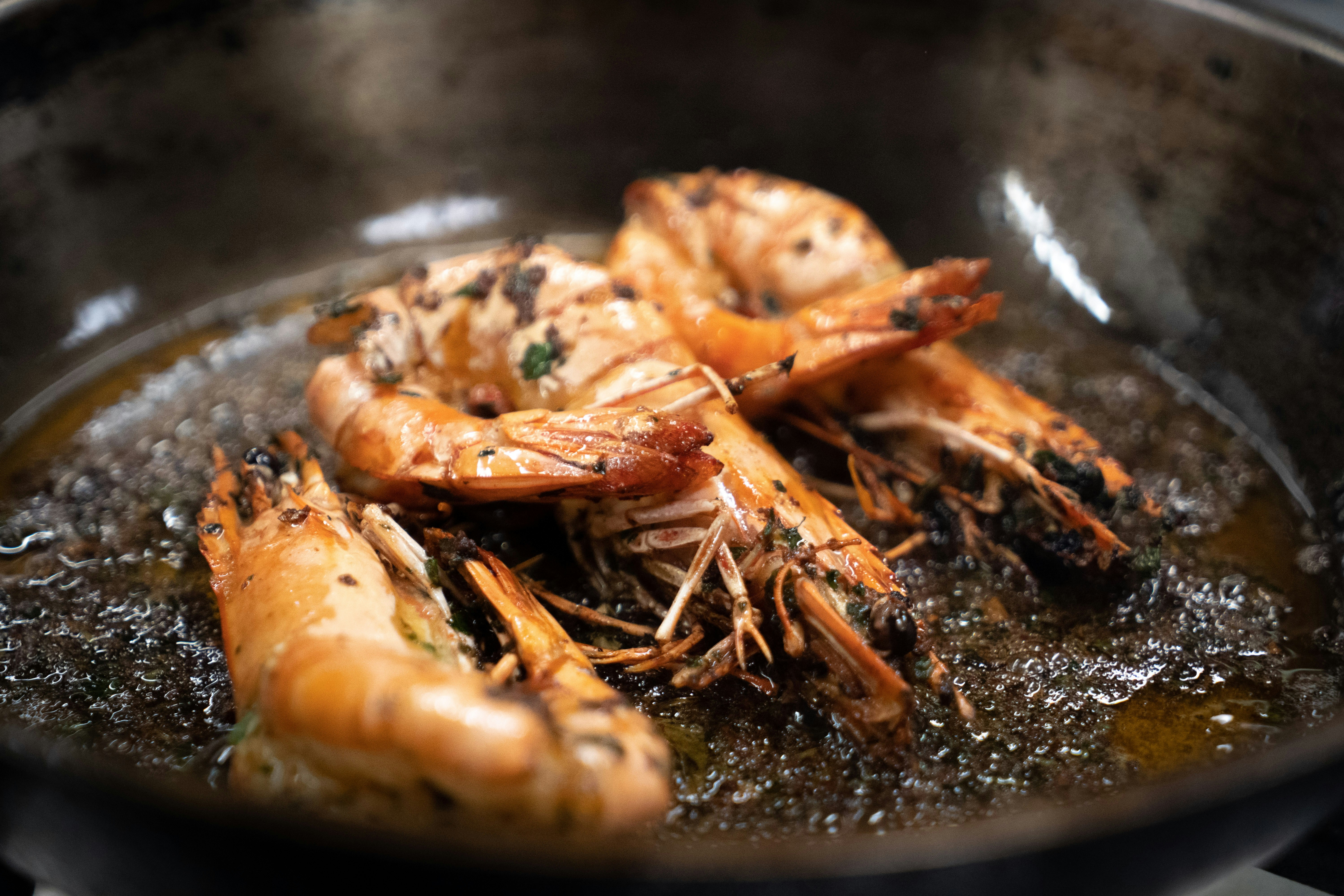 Grillet sjøkreps på trebord med smørsaus